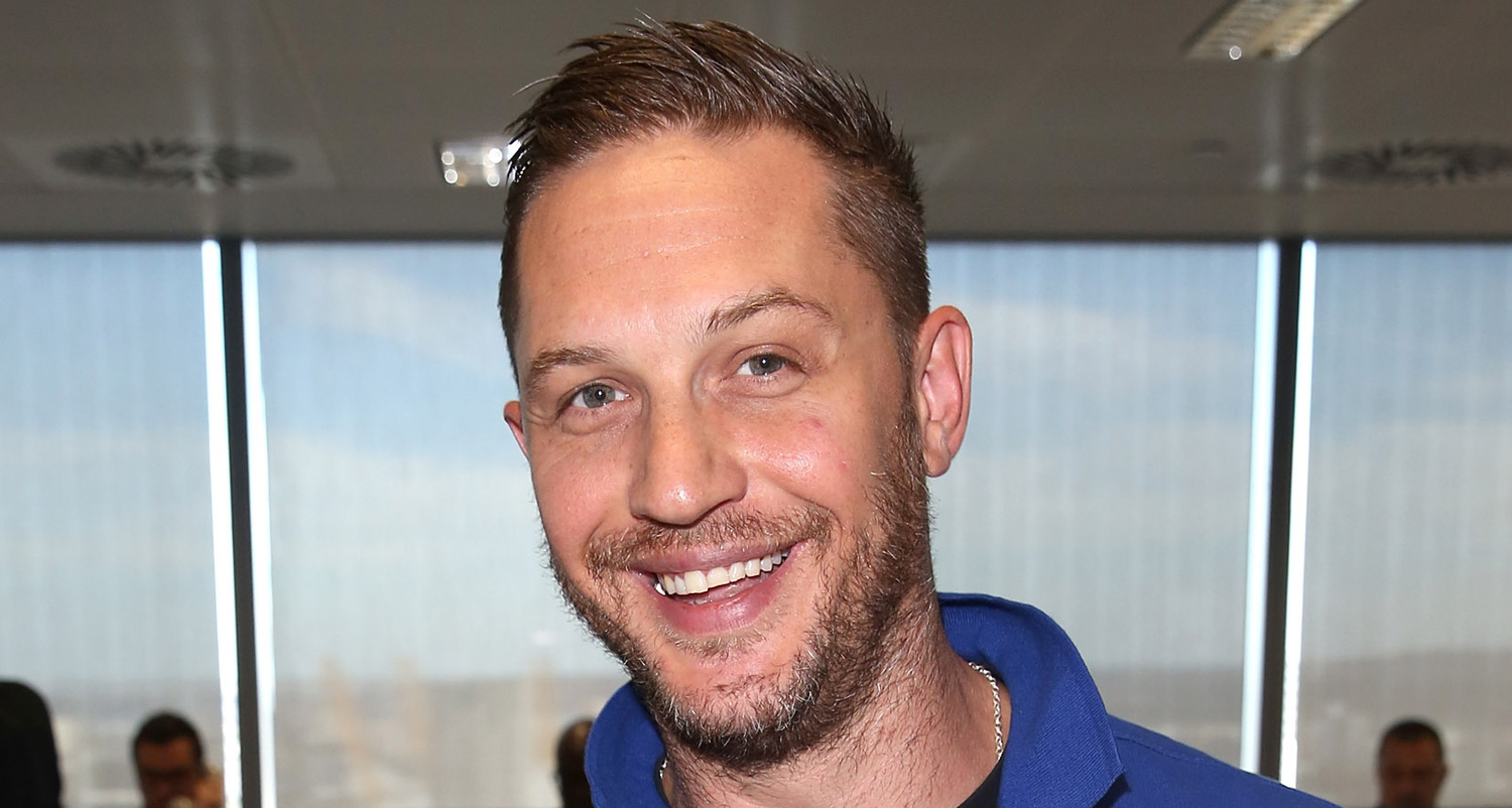 Close-up of Tom Hardy in 2025, smiling gently with natural-looking, well-aligned white teeth, highlighting the results of dental cleaning and oral care.